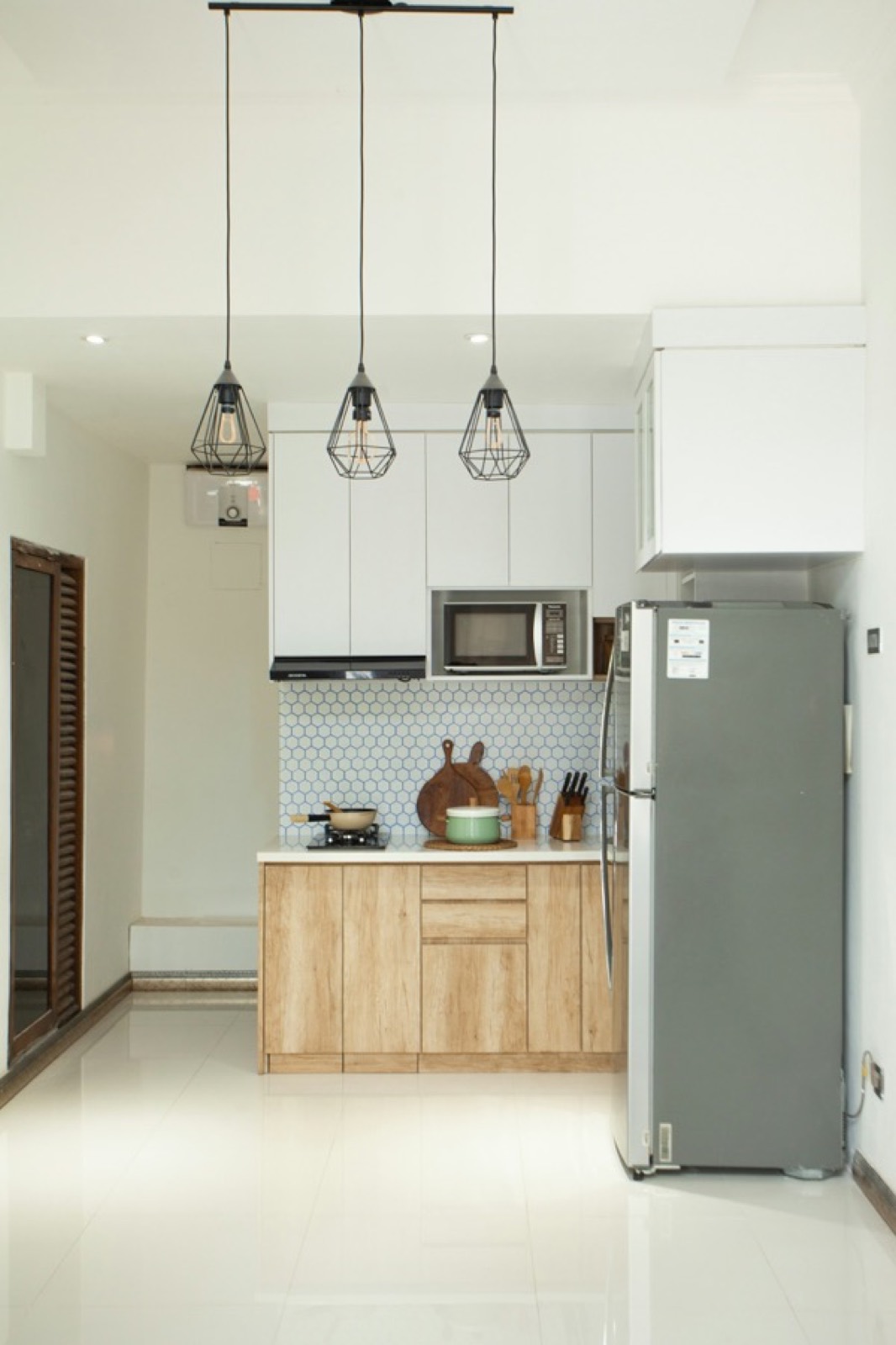 Compact kitchenette with a two-burner hob, microwave, fridge and utensils